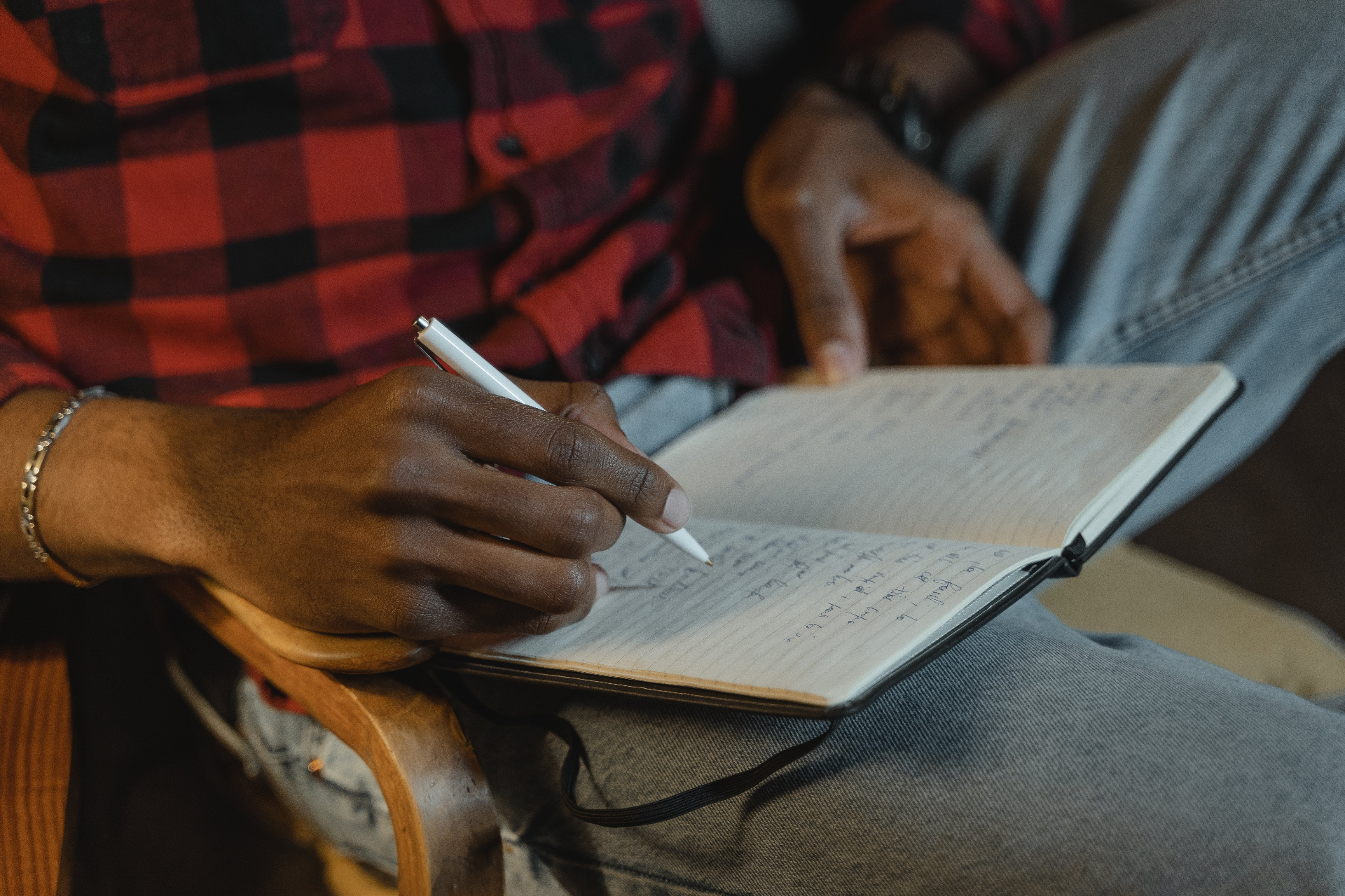 Person taking handwritten notes during a working session